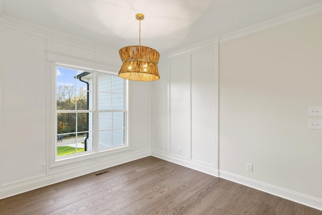 unfurnished dining area with hardwood / wood-style floors, plenty of natural light, and crown molding