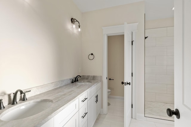 bathroom featuring tiled shower, tile patterned floors, vanity, and toilet