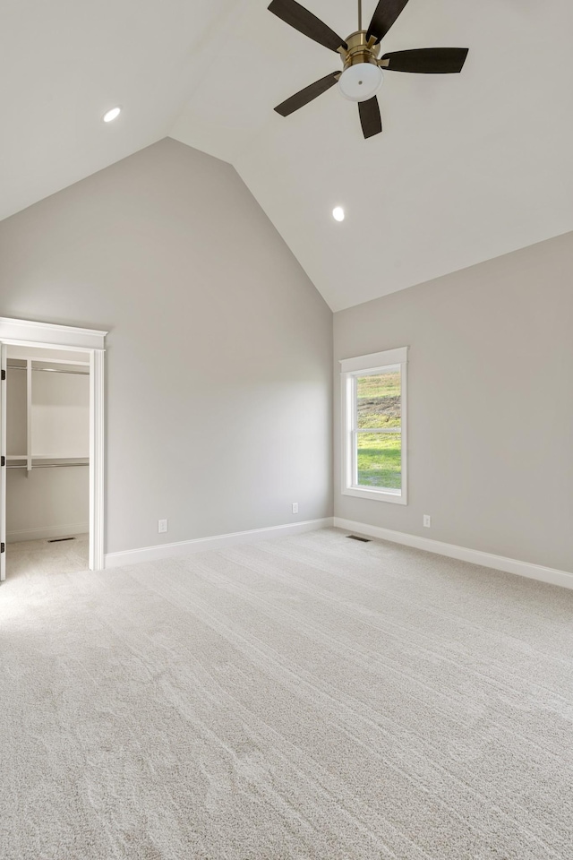 interior space with ceiling fan, lofted ceiling, and light carpet