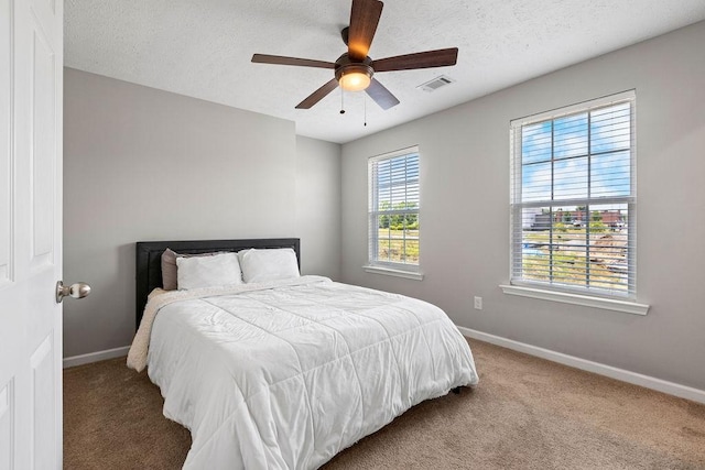 bedroom featuring carpet flooring, a textured ceiling, and ceiling fan