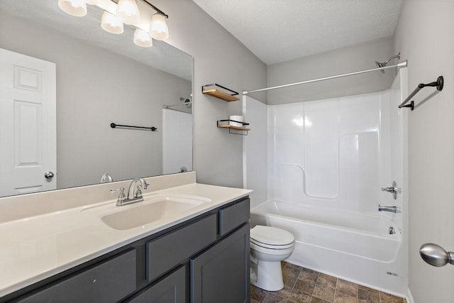 full bathroom featuring vanity, a textured ceiling, toilet, and washtub / shower combination