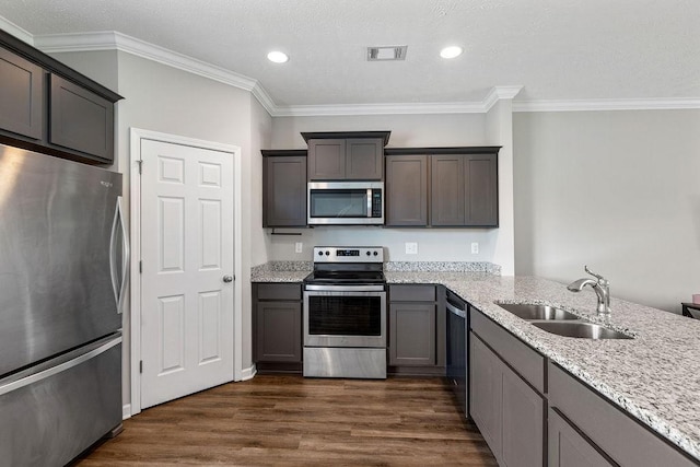 kitchen featuring crown molding, sink, light stone countertops, appliances with stainless steel finishes, and dark hardwood / wood-style flooring