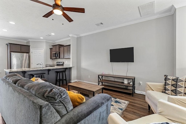 living room featuring dark hardwood / wood-style floors, ceiling fan, and ornamental molding