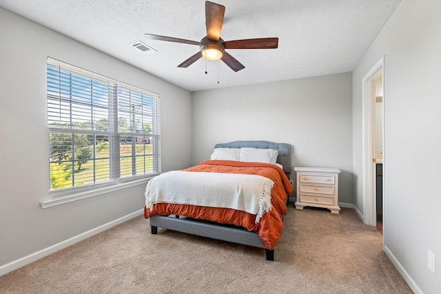 bedroom featuring ceiling fan, carpet floors, and a textured ceiling