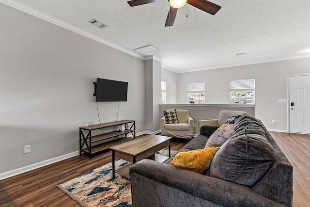 living room featuring hardwood / wood-style flooring, ceiling fan, ornamental molding, and a textured ceiling