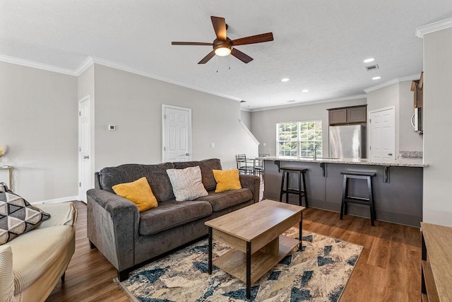 living room with sink, ceiling fan, dark hardwood / wood-style flooring, and crown molding