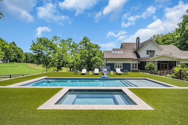 view of pool featuring an in ground hot tub and a yard