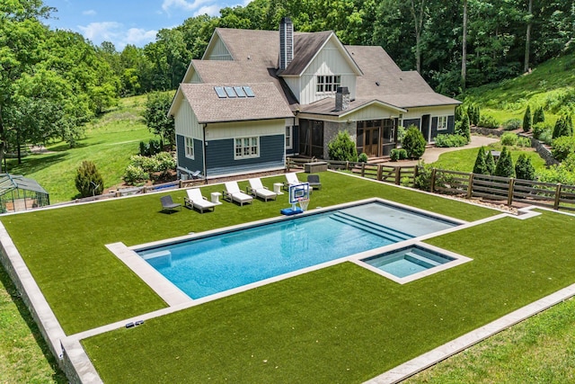 back of house with a lawn and a swimming pool with hot tub