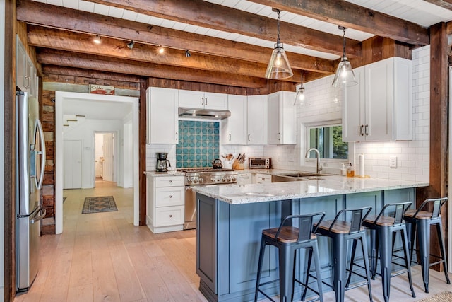 kitchen with appliances with stainless steel finishes, light stone counters, sink, beam ceiling, and white cabinets