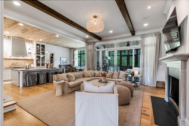 living room with beamed ceiling, light wood-type flooring, and a premium fireplace