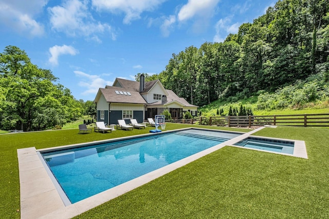 view of swimming pool with an in ground hot tub and a lawn