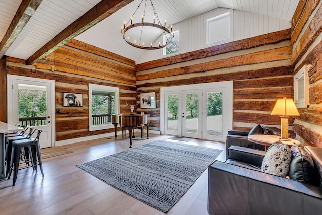 living room featuring french doors, light hardwood / wood-style floors, high vaulted ceiling, and a notable chandelier