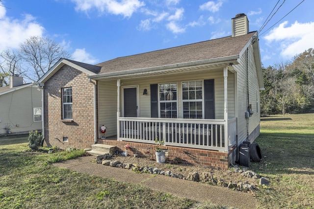 bungalow-style home with covered porch and a front lawn