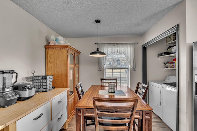 dining space with washing machine and dryer, dark hardwood / wood-style floors, and a textured ceiling