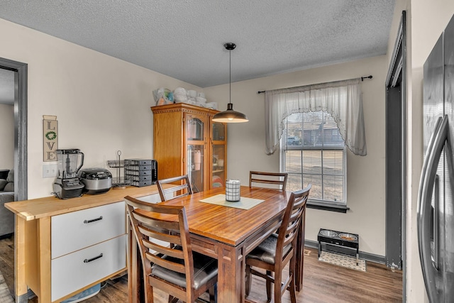 dining room with hardwood / wood-style floors and a textured ceiling