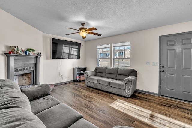 living room with ceiling fan, dark wood-type flooring, and a textured ceiling