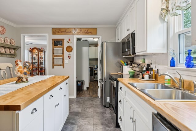 kitchen with white cabinetry, sink, appliances with stainless steel finishes, and wood counters