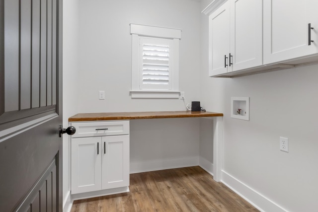 clothes washing area with cabinets, hookup for a washing machine, and light hardwood / wood-style floors