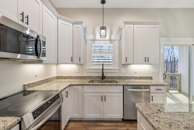 kitchen with white cabinets, stainless steel appliances, hanging light fixtures, and sink