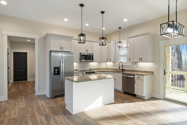 kitchen featuring a wealth of natural light, white cabinetry, pendant lighting, a kitchen island, and appliances with stainless steel finishes