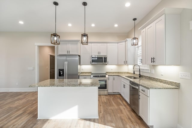 kitchen featuring white cabinetry, sink, a center island, and stainless steel appliances