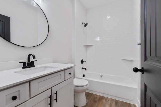 full bathroom with vanity, wood-type flooring, tiled shower / bath combo, and toilet