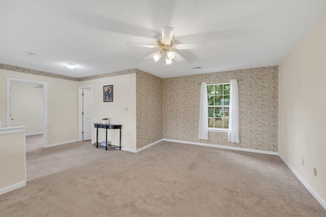 carpeted spare room with ceiling fan and a textured ceiling