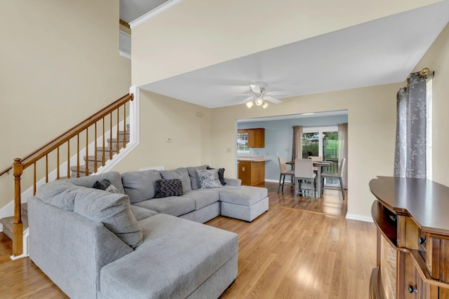 living room with light hardwood / wood-style flooring, ceiling fan, and crown molding