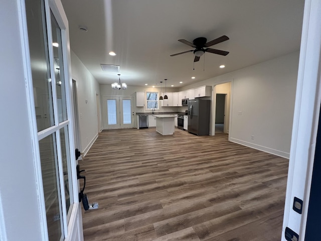 unfurnished living room with sink, dark hardwood / wood-style floors, and ceiling fan with notable chandelier