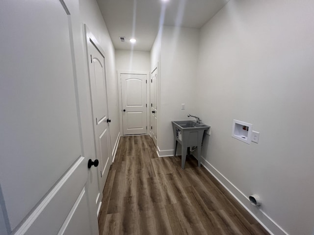 laundry room with hookup for a washing machine, dark hardwood / wood-style floors, and sink