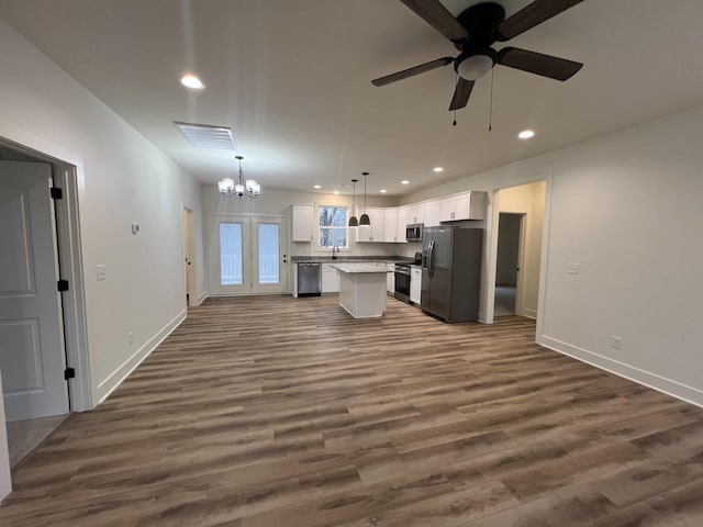 kitchen featuring white cabinetry, a center island, stainless steel appliances, dark hardwood / wood-style flooring, and decorative light fixtures