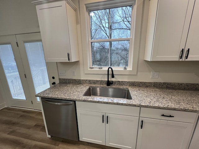 kitchen with dishwasher, white cabinets, light stone countertops, and sink