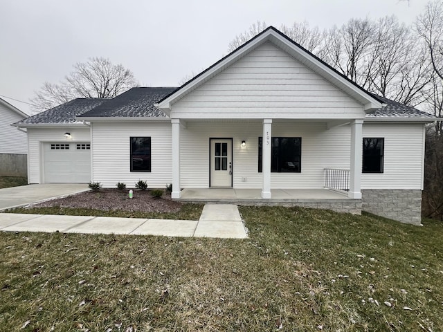 view of front facade featuring covered porch, a garage, and a front yard