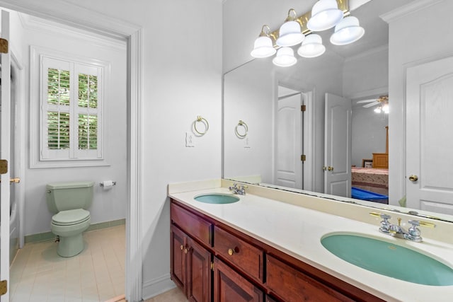 bathroom with vanity, ceiling fan with notable chandelier, toilet, and crown molding