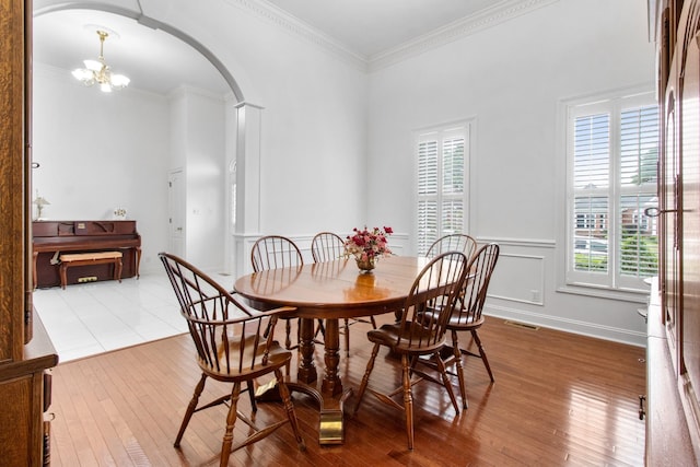 dining area with hardwood / wood-style flooring, a healthy amount of sunlight, and an inviting chandelier