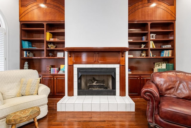 sitting room featuring dark hardwood / wood-style floors and a tiled fireplace