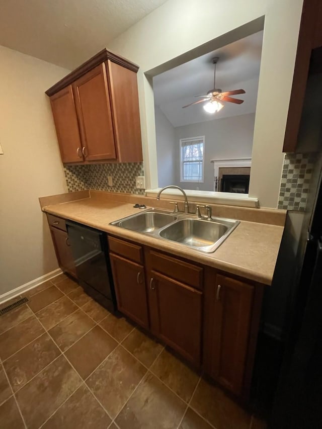 kitchen with ceiling fan, dishwasher, decorative backsplash, sink, and dark tile patterned floors