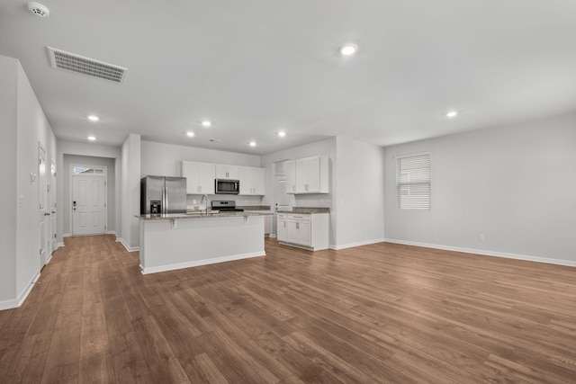 kitchen featuring hardwood / wood-style floors, white cabinets, sink, an island with sink, and appliances with stainless steel finishes