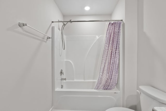 bathroom featuring toilet and shower / bathtub combination with curtain