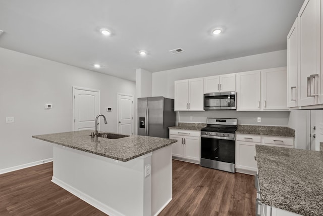 kitchen with appliances with stainless steel finishes, a center island with sink, white cabinetry, and sink