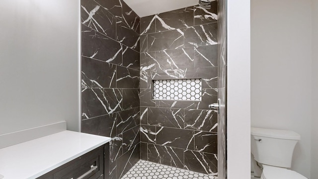 bathroom featuring a tile shower and toilet