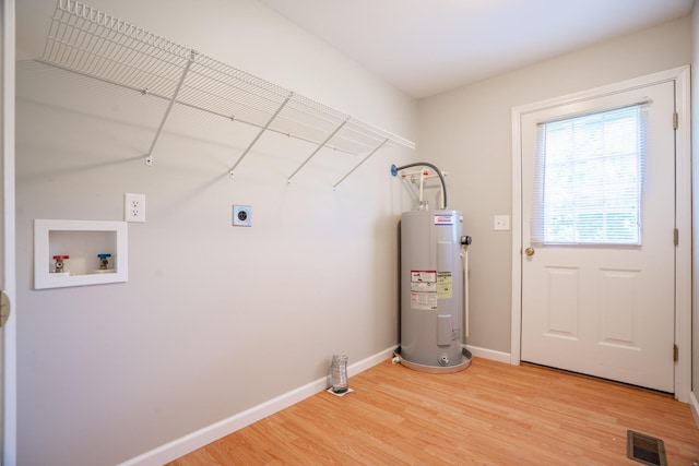 laundry area featuring water heater, hookup for a washing machine, hardwood / wood-style floors, and hookup for an electric dryer