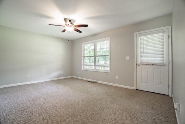 carpeted spare room featuring ceiling fan