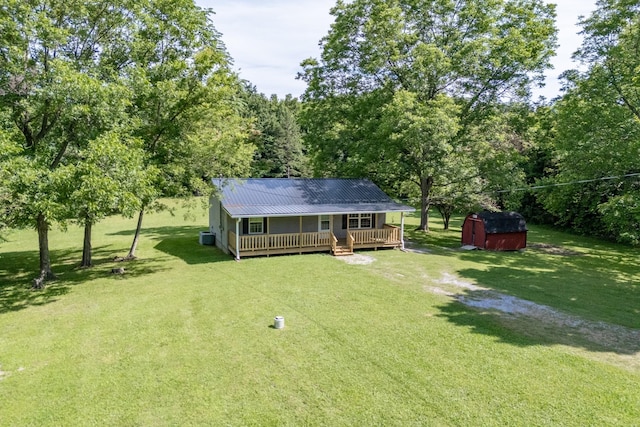 view of yard with a wooden deck, central AC unit, and a storage shed