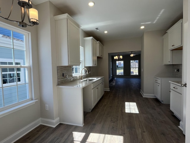 kitchen featuring white cabinetry, light countertops, and a sink