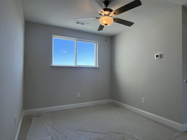 empty room with baseboards, visible vents, and ceiling fan