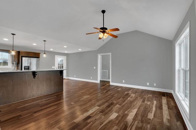 unfurnished living room featuring lofted ceiling, ceiling fan, and dark wood-type flooring