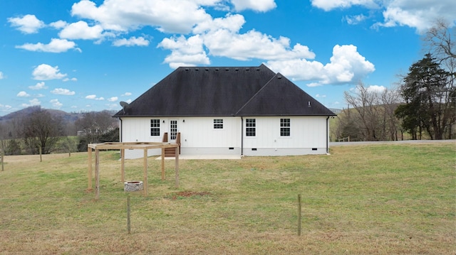 back of house featuring a mountain view and a yard