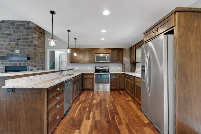 kitchen featuring light stone countertops, dark hardwood / wood-style flooring, stainless steel appliances, sink, and decorative light fixtures