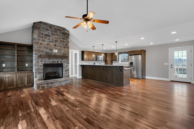 unfurnished living room with ceiling fan, built in features, dark hardwood / wood-style floors, vaulted ceiling, and a fireplace